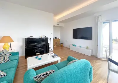a living room with a blue couch and a tv at Solemar Sicilia - Villa delle Rocce in Bagheria