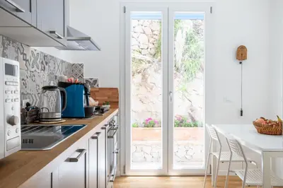a kitchen with a white counter and a window at Solemar Sicilia - Villa delle Rocce in Bagheria