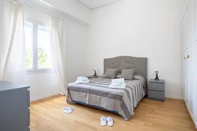a white bedroom with a bed and a window at Solemar Sicilia - Villa delle Rocce in Bagheria