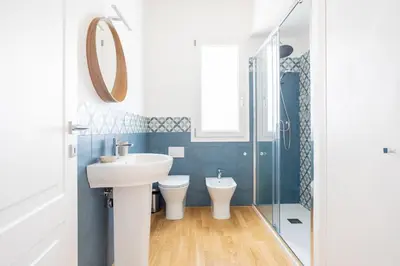 a bathroom with a sink and a toilet and a mirror at Solemar Sicilia - Villa delle Rocce in Bagheria