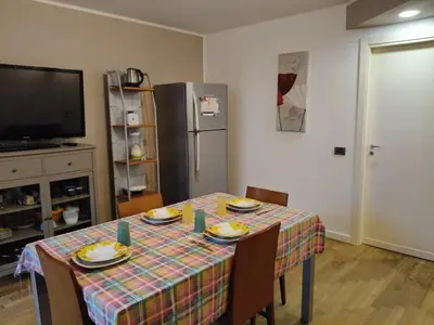 a dining room with a table with chairs and a television at Casabella Mondello in Mondello