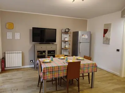 a dining room with a table and a refrigerator at Casabella Mondello in Mondello