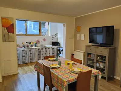 a dining room with a table with chairs and a television at Casabella Mondello in Mondello