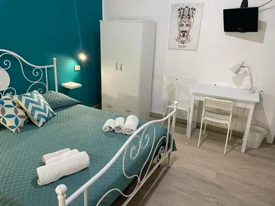 a bedroom with a bed with a table and a desk at Casa Vittoria in Palermo