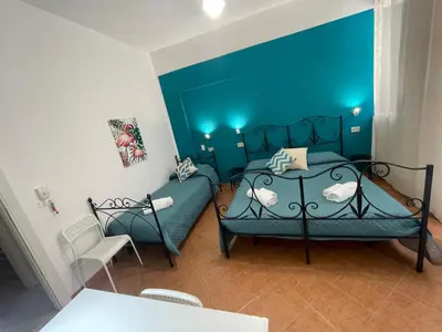a blue bedroom with a bed and a chair at Casa Vittoria in Palermo