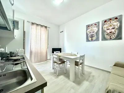 a kitchen and dining room with a white table and chairs at Casa Pascal in Palermo