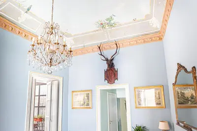 a dining room with a chandelier and a ceiling at Dimora Lecerf in Palermo