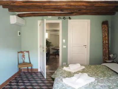 a bedroom with two beds and a chair in a room at Dimora Lecerf in Palermo