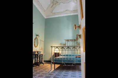 a bedroom with a bed and a table with a mirror at Dimora Lecerf in Palermo