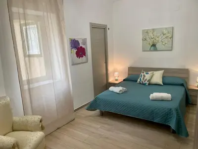 a bedroom with a bed and a chair and a dresser at Maqueda Apartament for 4 Palermo Centre Ballarò in Palermo