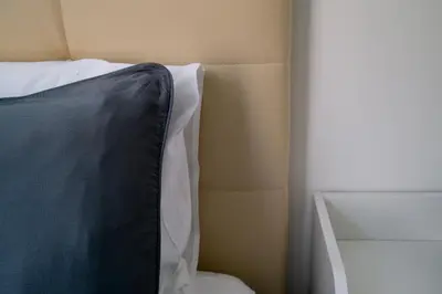 a black and white pillow sitting on top of a bed at AUSA suites in Palermo