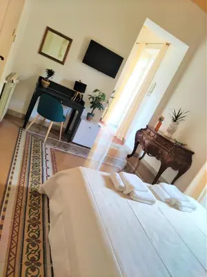 a bedroom with a bed and a desk and a piano at AUSA suites in Palermo
