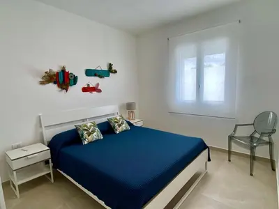 a bedroom with a blue bed and a window at Katy's Holiday House, Private Villa and Pool in Terrasini