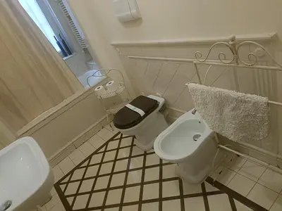 a white bathroom with a toilet and a sink at onoratocinque house apartment in Palermo