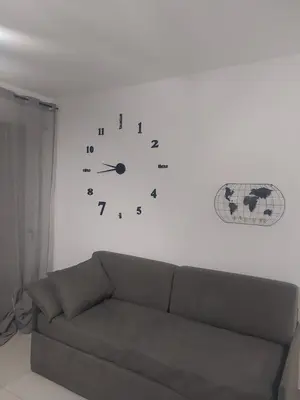 a clock on a white wall next to a couch at Casa d'a-mare in Terrasini