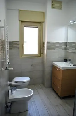 a bathroom with a toilet and a sink and a window at B&B Casa Canali in Palermo