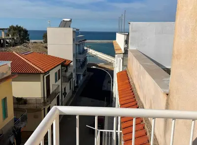 a view of an alley between buildings and the ocean at Casa Scirocco in Balestrate