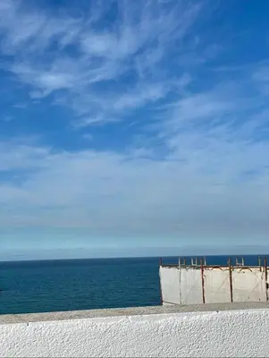 a building on the beach with the ocean in the background at Casa Scirocco in Balestrate