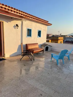 a patio with two chairs and a bench on a roof at Casa Scirocco in Balestrate