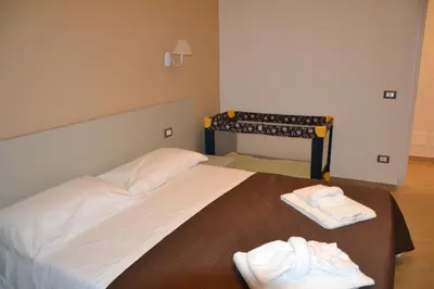 a bedroom with a bed with two towels on it at Villa del Principe in Carini