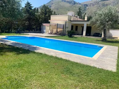 a villa with a swimming pool in front of a house at Villa del Principe in Carini