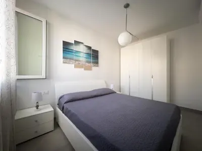 a bedroom with a blue bed and a white cabinet at Savoia's apartments in San Vito lo Capo