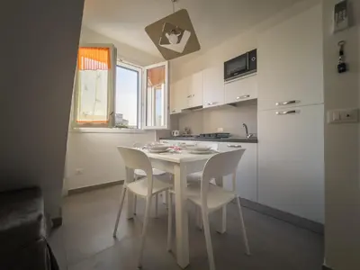 a small kitchen with a white table and chairs at Savoia's apartments in San Vito lo Capo