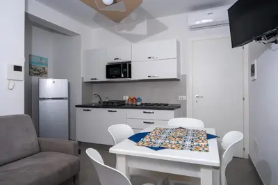 a kitchen with a white table and a table and chairs at Savoia's apartments in San Vito lo Capo