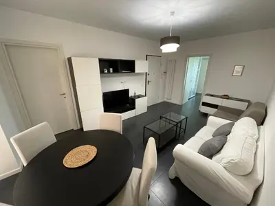 a living room with a black table and white chairs at Zanclea in Palermo