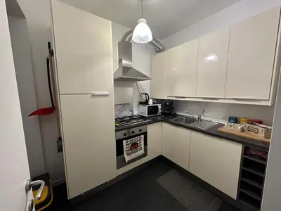 a kitchen with white cabinets and a stove top oven at Zanclea in Palermo