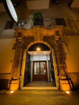 an entrance to a building at night with a door at Hotel Posta in Palermo