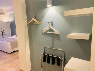 a room with a wall with hangers and a bed at Hotel Posta in Palermo