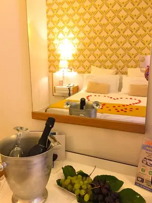 a bottle of wine and grapes on a counter in a room at Hotel Posta in Palermo
