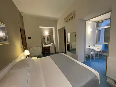 a bedroom with a large white bed and a bathroom at Hotel Posta in Palermo