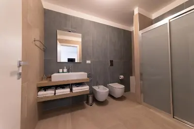 a bathroom with a sink and a toilet and a mirror at Alta Marea Sea Apartments in Balestrate