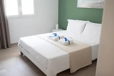 a bedroom with a white bed with towels on it at Alta Marea Sea Apartments in Balestrate