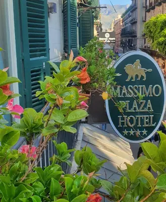 a sign for a masina tala hotel next to flowers at Massimo Plaza Hotel in Palermo