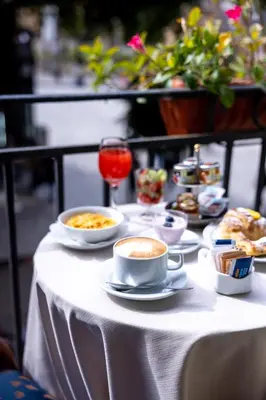 a table with dishes of food and a cup of coffee at Massimo Plaza Hotel in Palermo