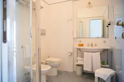 a bathroom with a toilet and a sink and a mirror at Hotel Punta Nord Est in Castellammare del Golfo