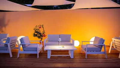 a room with blue chairs and a table and a yellow wall at Hotel Punta Nord Est in Castellammare del Golfo