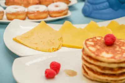 a plate of food with pancakes and raspberries on it at Hotel Cetarium in Castellammare del Golfo