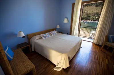 a bedroom with a bed and a large window at Hotel Cetarium in Castellammare del Golfo