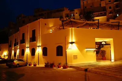 a building with lights on the side of it at night at Hotel Cetarium in Castellammare del Golfo