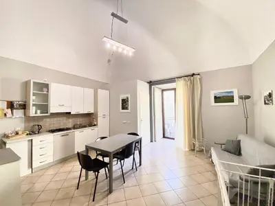 a kitchen and living room with a table and a couch at La Ginestra in Corleone