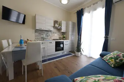 a kitchen with a blue couch and a table in a room at Terra Sinus Luxury apartment in Terrasini