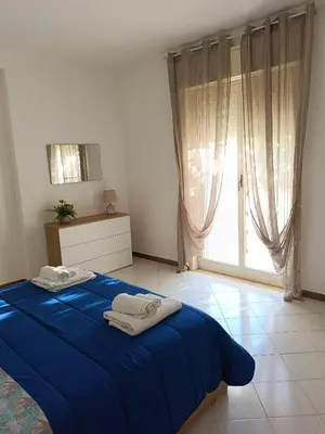 a bedroom with a blue bed and a large window at Casa il Bergamotto in Palermo