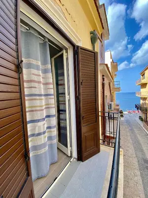 a door to a balcony with a view of the ocean at Casa vacanze stella marina in Trappeto