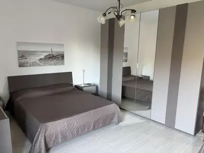 a bedroom with a bed and a mirror at Casa Maria Costa Blu in Isola delle Femmine