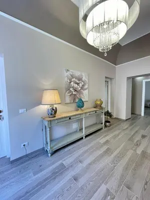 a living room with a table and a chandelier at Domus Federiciana in Castellammare del Golfo