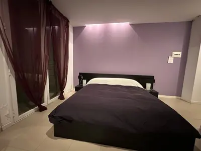 a bedroom with a large bed with purple walls at Malusi B&B in Sferracavallo